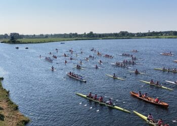 Vloot van jubilerende roeivereniging uit Heemstede voor groepsfoto op Molenplas