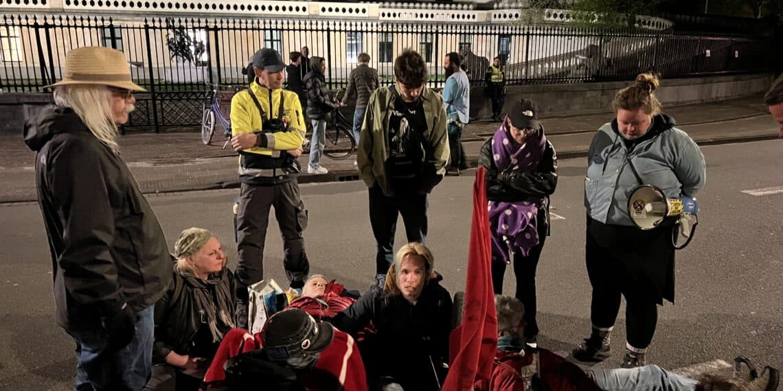Vastgelijmde klimaatactivisten brengen de nacht door op het asfalt voor het provinciehuis