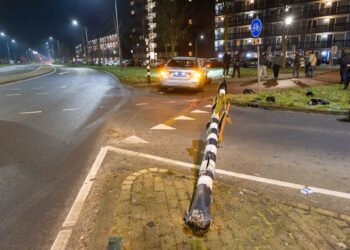 Taxi rijdt verkeerslicht uit de grond op Vondelweg in Haarlem